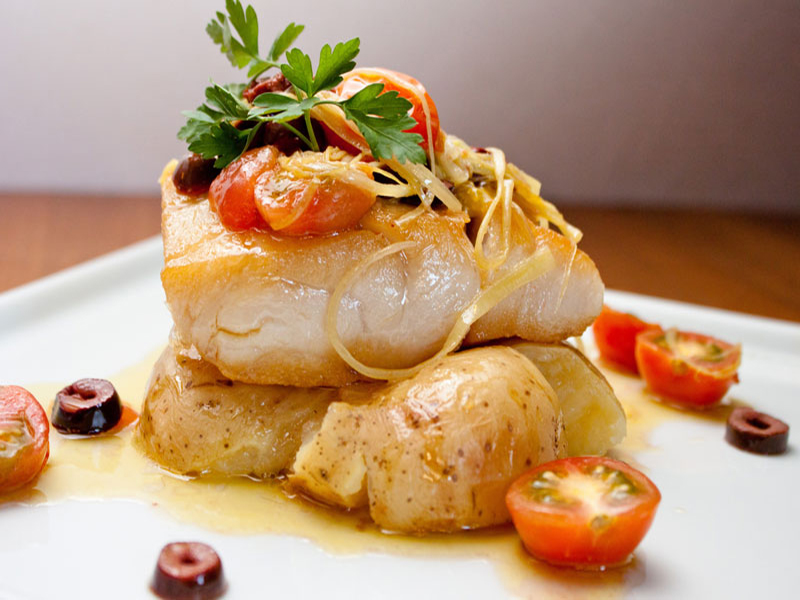 close-up of a whitefish filet and garnish on top of potatoes