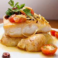 close-up of a whitefish filet and garnish on top of potatoes