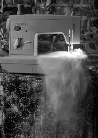 a vintage sewing machine with a ghostly fabric passing through it